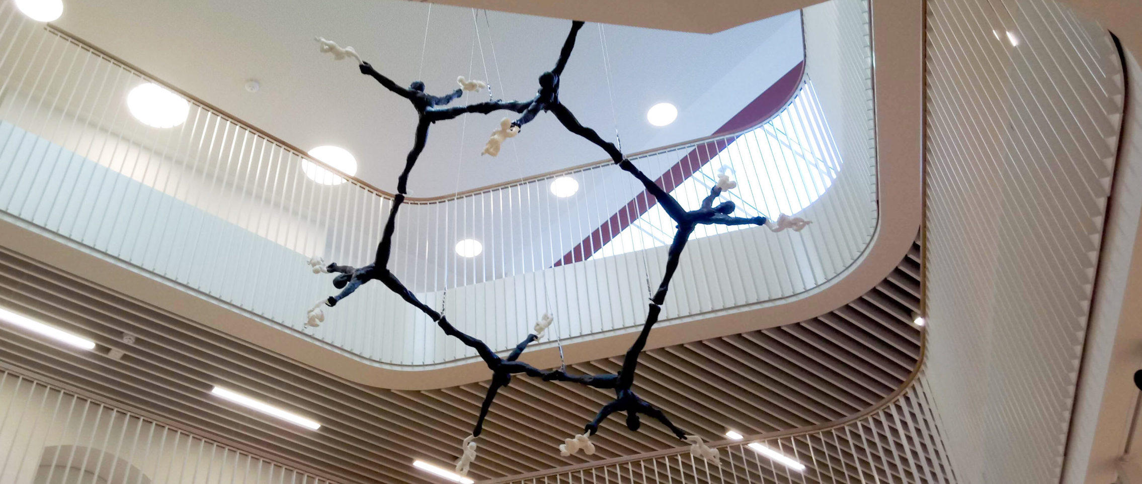 Sculpture of a hexagonal molecule made from human figures cast in bronze