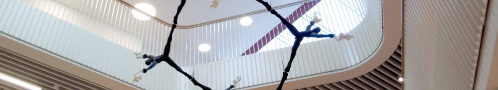 Sculpture of a hexagonal molecule made from human figures cast in bronze