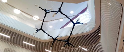 Sculpture of a hexagonal molecule made from human figures cast in bronze