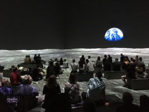 People watching an immersive projection of the moon