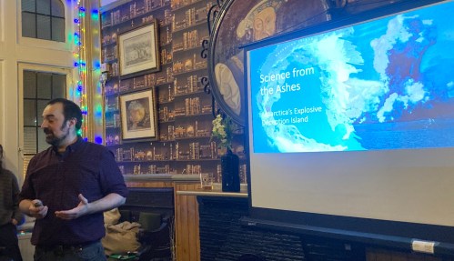 A man in front of a projector screen