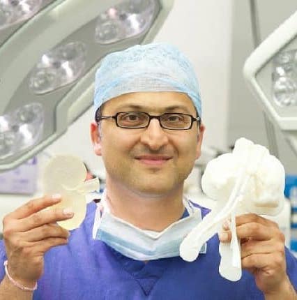 A surgeon holding 3D printed models of a kidney ready for transplant and its intended destination