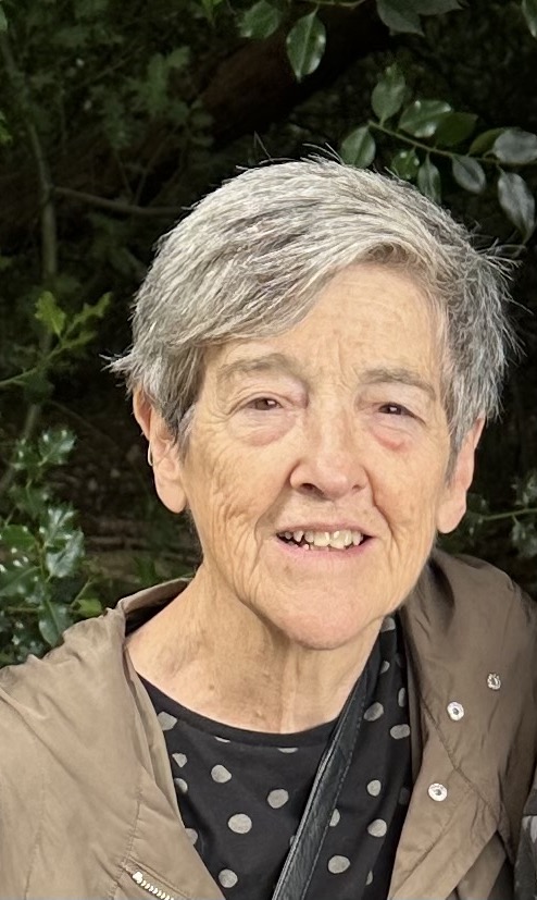 A woman in front of holly bushes